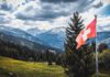 The flag of Switzerland with a view on the land