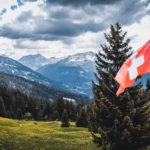 La inflación en Suiza se duplicará este año. The flag of Switzerland with a view on the land