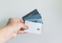 Bank Capital One buys credit card issuer Discover for $35 billion USD Credit cards, american, capital one, hand holding cards.